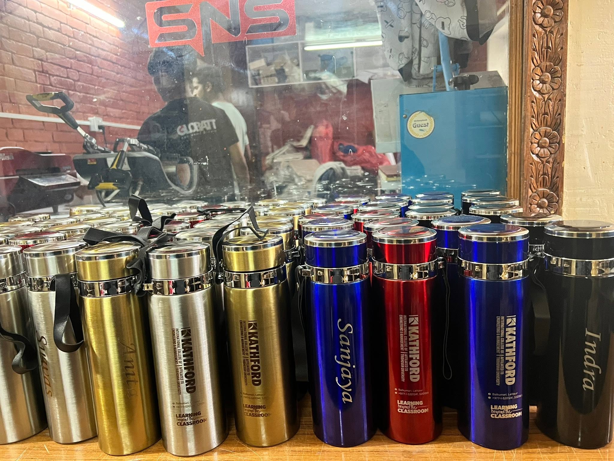 Shelf of personalised engraved flasks with names